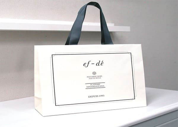 Túi giấy kraft trắng đen đựng quần áo in thương hiệu doanh nghiệp