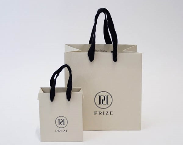 Túi kraft trắng quai dây đen in logo thương hiệu ở trung tâm